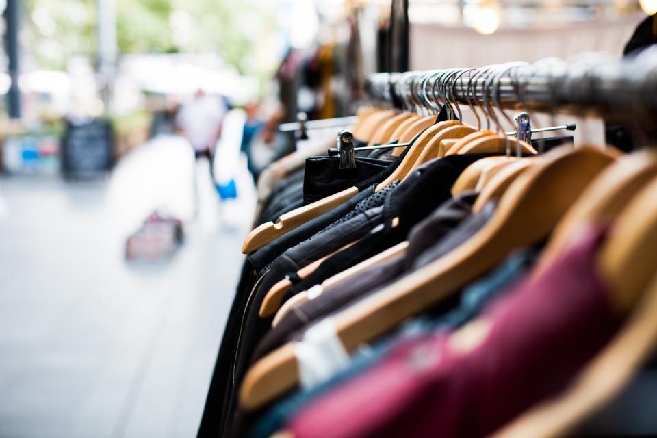 Arara de loja de roupas com peças coloridas penduradas em cabides
