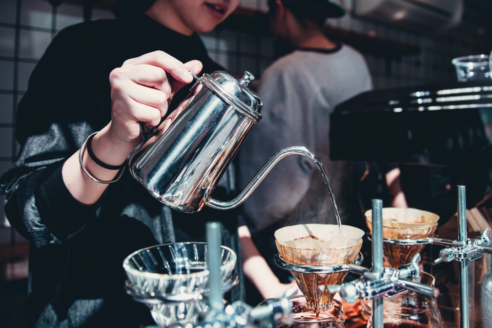 Barista preparando café coado no balcão de uma cafeteria