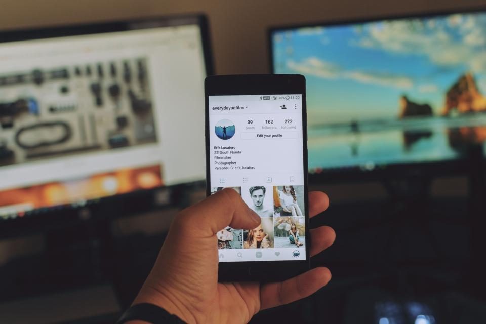 Celular mostrando um perfil do Instagram com a grade de fotos