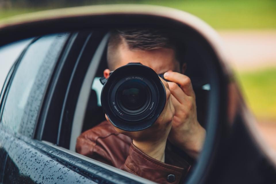Fotógrafo apontando a câmera de dentro de um carro
