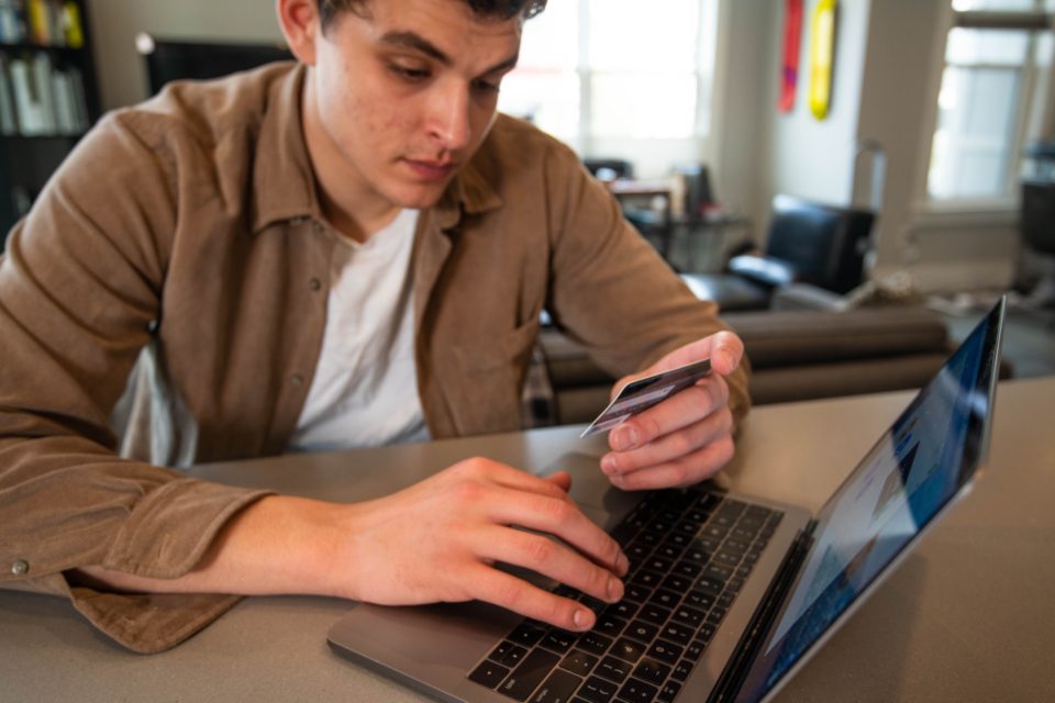 Homem trabalhando no notebook sentado à mesa de um escritório