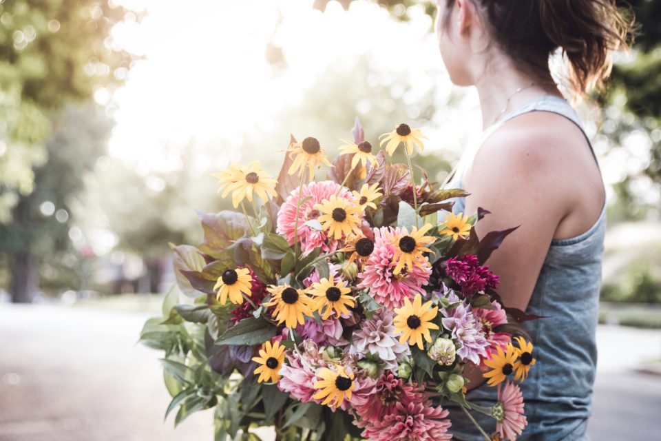 Mulher segurando um buquê de flores coloridas