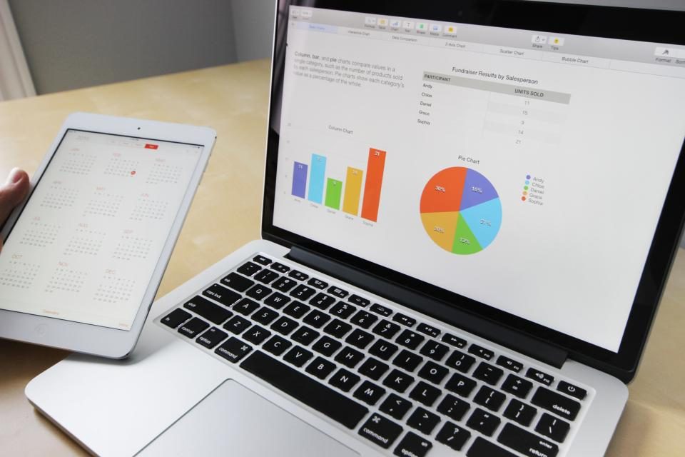 Notebook e tablet mostrando gráficos de barras e de pizza